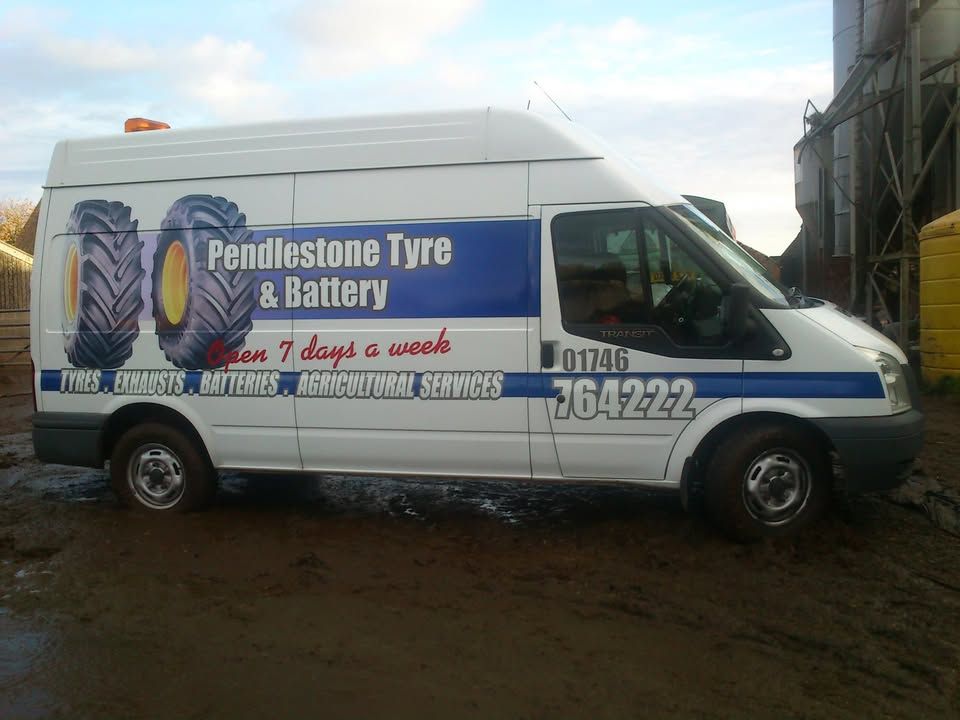 The white Pendlestone Tyre & Battery Transit van with blue livery and tractor tyres painted on the side